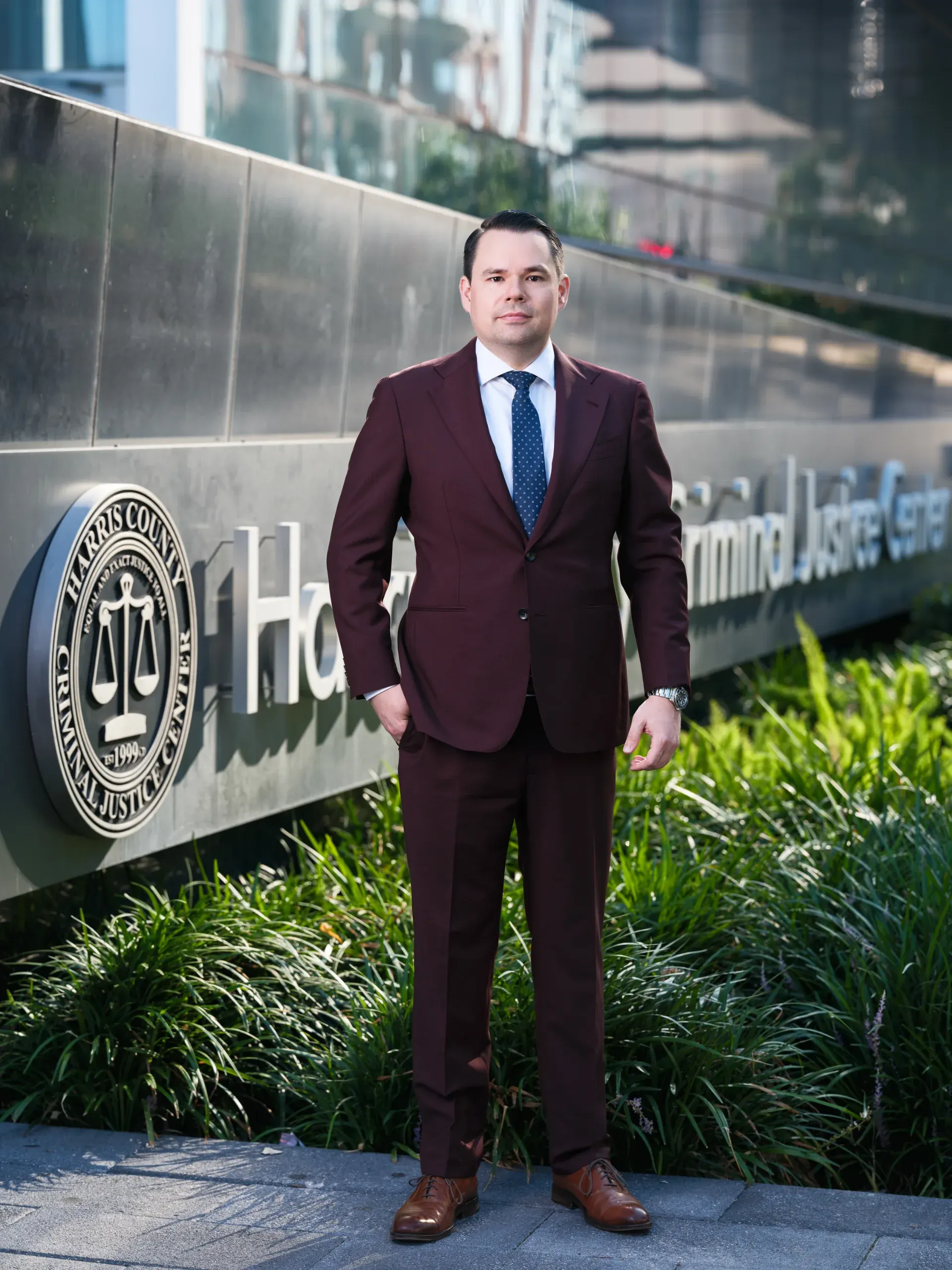 Houston attorney in a burgundy suit outside the Harris County Criminal Justice Center