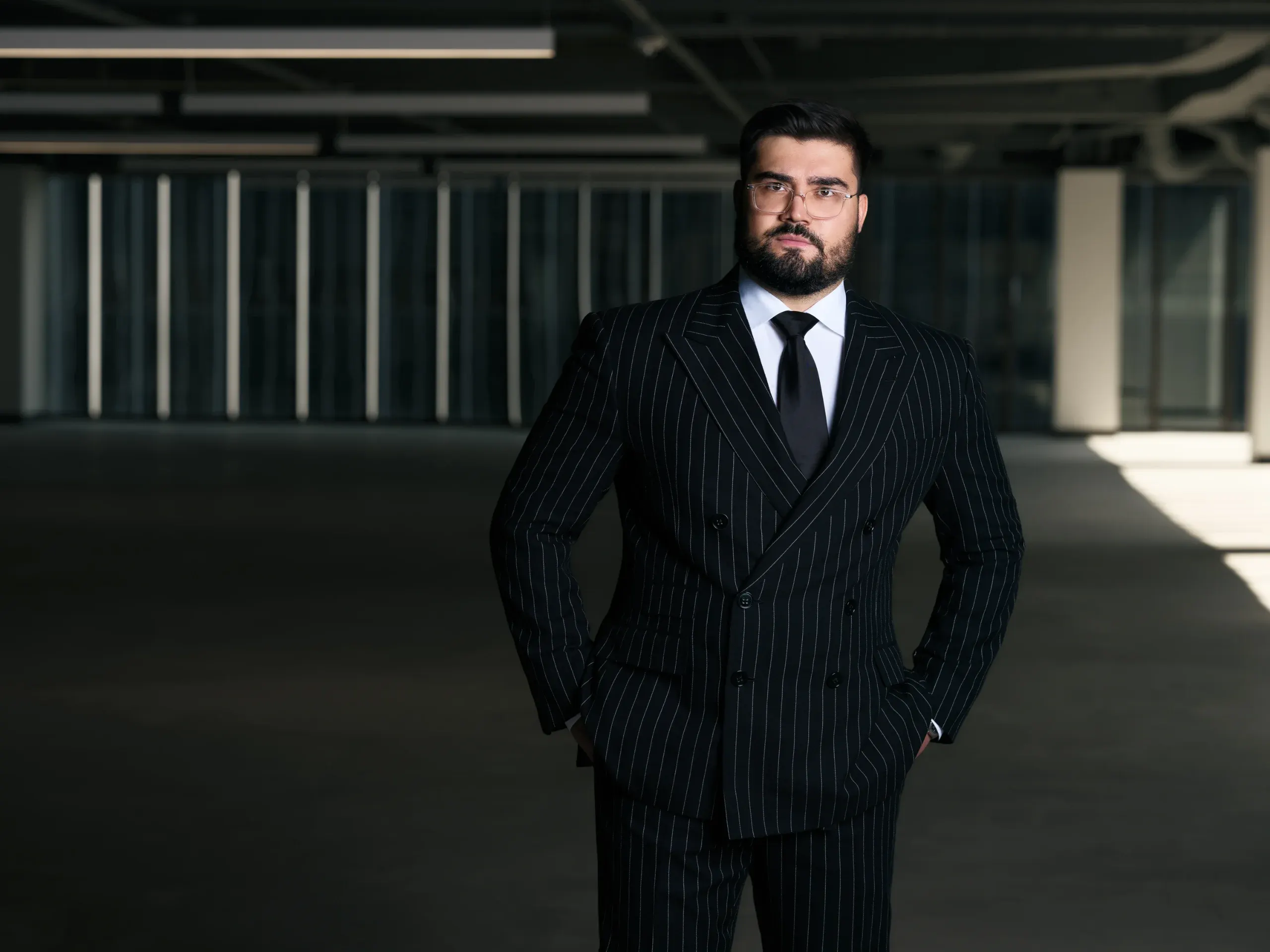 Houston attorney in a double-breasted pinstripe suit standing in an empty open-plan office